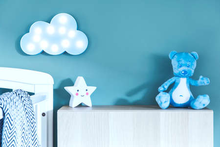 Stylish nursery interior with photo frame, teddy bear, star and blue cloud. Blue background wall.の写真素材