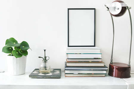 Stylish home interior with mock up white frame ,plants, vintage sprinkler and lamp on the shelf. Modern oncept of mock up frame.の写真素材