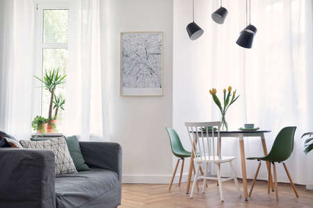 Stylish and modern open space with dining and living room with design map, sofa and family table....