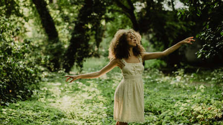 Young and beautiful girl dancing ballet in the secret garden. Natural scenery in the forest.の写真素材