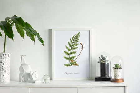 Scandinavian modern cupboard with mock up poster frame, design vase, tropical leaf, succulents in...