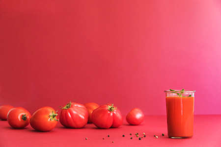Fresh and summer tomato smoothies and tomato fruits and pepper on the red background. Many vitamins and minerals for healthy mind and body.の写真素材
