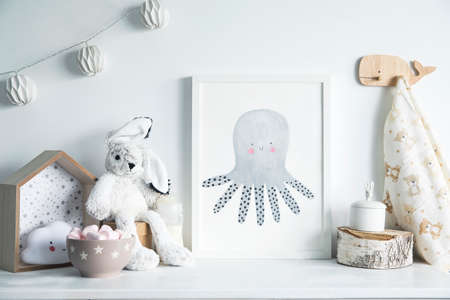 Stylish scandinavian newborn baby room with toys, rabbit, cotton lamps and star. Modern interior with mock up photo frame.の写真素材