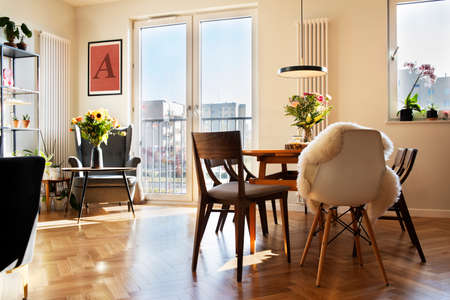 Cozy scandinavian open space with dining, living room and kitchen with design sofa and family table....