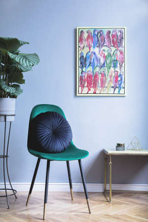 Grey luxury interior with green design velvet chair, pillow, coffee table and tropical plant. Modern composition with mockup image. Brown wooden parquet.の写真素材