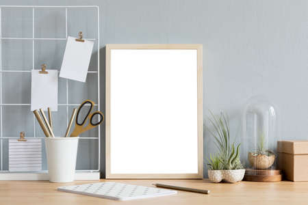 Home interior of creative desk with mock up photo frame on the brown wooden table with office...
