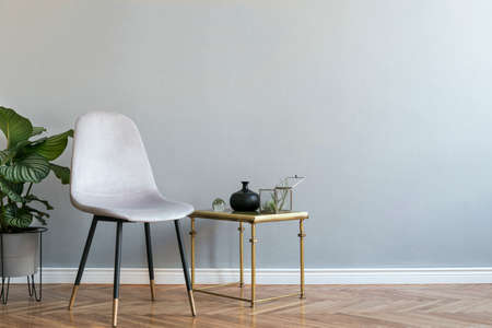 Luxury and minimalistic grey home interior with grey velvet chair, table with accessories and...