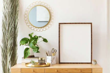Stylish scandinavian interior with living room with mock up poster frame, gold mirror, wooden desk...