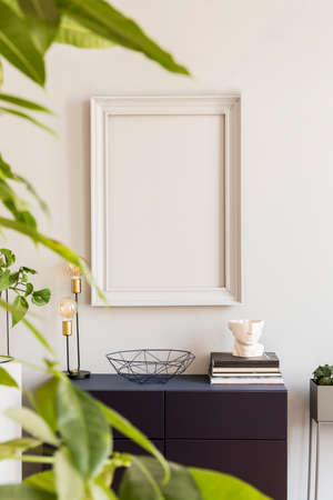 Scandinavian and design home decor with mock up gray poster frame, navy blue shelf with stylish...