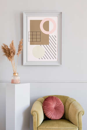 Minimalistic and luxury living room of apartment interior with elegant green armchair, gray stand and chic accessories. Mock up paintings frame on the molding gray wall. Stylish home decor. Template.の写真素材