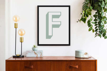 Stylish retro room interior with design cabinet, lamp, modern accessories and black mock up poster...