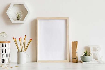 Modern and stylish home interior with wooden mock up poster frame, design office accessories, tapes,...