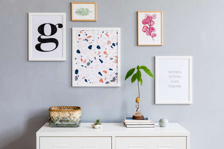 The stylish scandinavian interior of living room at design apartment with mock up poster frames...