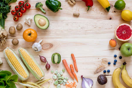 Modern composition of fresh healthy vegetables and fruits on the wooden table in the kitchen....