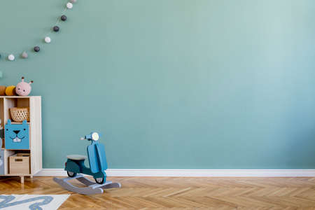 Scandinavian nursery room with wooden cabinet, design children's motor toy and plush toys. Cute...