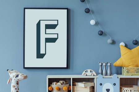 Stylish scandinavian newborn baby room with wooden cabinet, toys, mock up poster frame and...