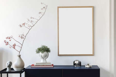 Stylish scandinavian living room with mock up poster frame, navy blue commode, plants, flowers in vase and elegant accessories. Modern home decor. Interior design. Template Ready to use.の写真素材
