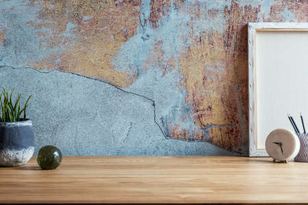 Stylish interior design of office space in loft apartment with wooden desk, office supplies, cacti and elegant accessories. Modern home office decor. Copy space. Retro wall Template.の写真素材