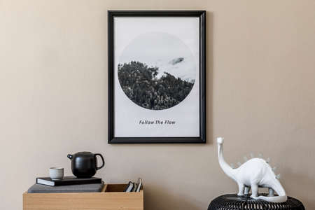 Stylish scandinavian living room interior with modern wooden commode, stylish lamps, rattan basket, sculpture and elegant personal accessories. Mock up photo frame on the beige wall. Template.の写真素材