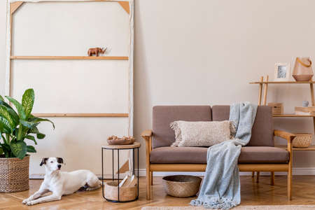 Interior design of living room with stylish brown wooden sofa, macrame, bookstand, lamp, coffee...