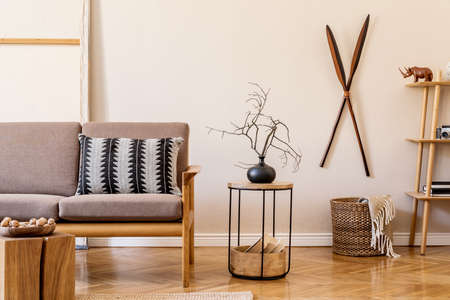 Interior design of living room with stylish brown wooden sofa, macrame, bookstand, lamp, coffee...