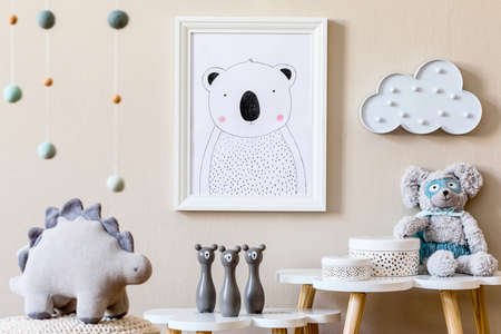 Stylish scandinavian nursery interior with mock up photo frame, toy, design furniture, pillows and accessories. Beautiful decoration on the beige background wall. Home decor for children room.の写真素材