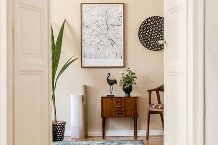 Modern scandinavian living room interior with brown mock up poster frame, design retro commode, chair, rattan decor, carpet, plants and elegant accessories. Template. Stylish home staging. Japandi.の写真素材