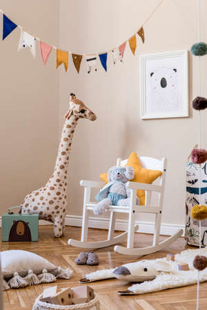 Stylish scandinavian interior of child room with natural toys, hanging decoration, design furniture, plush animals, teddy bears, mock up poster and accessories at modern home decor.の写真素材