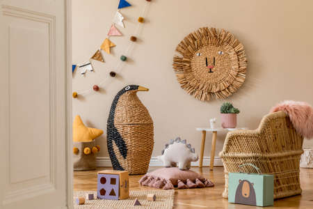 Stylish scandinavian interior of child room with natural toys, hanging decoration, design furniture, plush animals, teddy bears and accessories. Beige walls. Interior design of kid room. Template.の写真素材