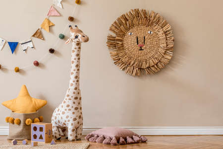 Stylish scandinavian interior of child room with natural toys, hanging decoration, design furniture, plush animals, teddy bears and accessories. Beige walls. Interior design of kid room. Template.の写真素材
