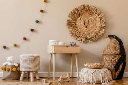 Stylish scandinavian interior of child room with natural toys, hanging decoration, design furniture, plush animals, teddy bears and accessories. Beige walls. Interior design of kid room. Template.の写真素材