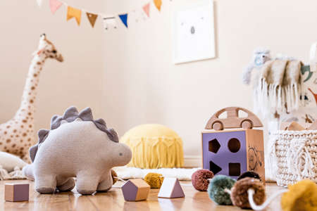 Stylish scandinavian interior of child room with mock up frame, natural toys, hanging decoration, design furniture, plush animals, teddy bears and accessories. Interior design of kid room. Template.の写真素材