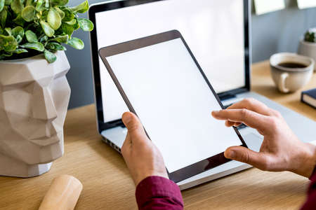 Modern business composition on the home office with freelancer, mock up tablet screen, plant, notes, mobile phone and office supplies in stylish concept of home decor.の写真素材