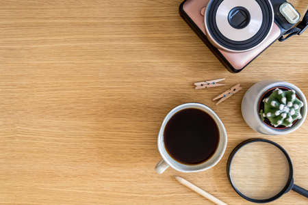 Stylish flat lay business composition on the wooden desk with photo camera, cacti, pen, copy space...