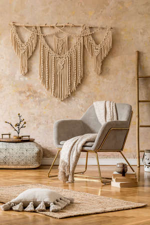 Stylish oriental living room with design armchair, beautiful macrame, carpet, decorations and...