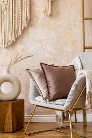 Interior design of oriental living room with modern armchair, macrame, velvet pillows, decorations and elegant personal accessories in stylish home decor.の写真素材