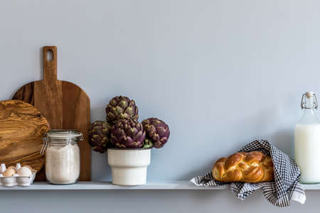 Modern composition on the kitchen interior with vegetables cutting board, food, herbs, kitchen accessories and copy space on the shelf.の写真素材