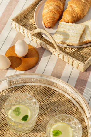 Stylish composition of outdoor kitchen space with wooden table, food, drinks, kitchen accessories,...