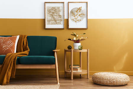 Stylish scandinavian interior of living room with design green velvet sofa, gold pouf, wooden...