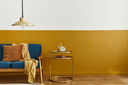Cozy interior with stylish velvet sofa, carpet on floor, copy space background, gold table, pendant...