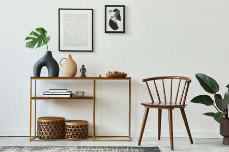 Stylish concept of living room interior with mock up poster frames, wooden console, chair, tropical...