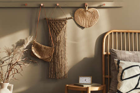 Modern interior design of stylish bedroom with decoration, neutral macrame, clothes hanger, dried...