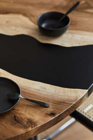 Minimalist composition on the design wooden and epoxy table with black teapot, cups and spoon. Modern dining room interior. Details. Template.の写真素材