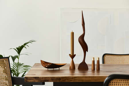 Modern concept of dining room interior with wooden oak table, chairs, plate with nuts, cnadle stick,...