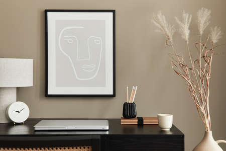 Stylish composition of home office interior with black wooden desk, chair, dried flower in vase,...
