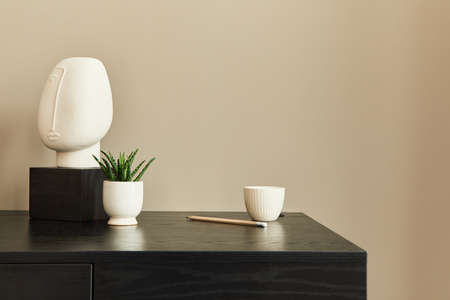 Stylish composition of office interior with black desk, design sculpture, plnat, notebook and desk...