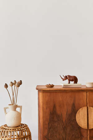 Minimalist composition of living room with copy space, plant, retro armchair, dried tropical leaf,...