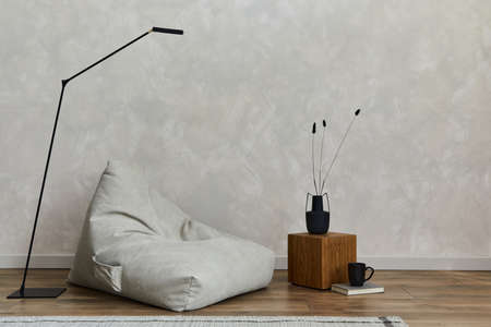 Creative composition of stylish modern spacious living room with pouf, wooden cubes, carpet, lamp,...
