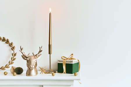 Christmas composition on the white chimney at the living room interior with beautiful decoration. Christmas tree and wreath, candles, stars, light. Copy space. Template.の写真素材