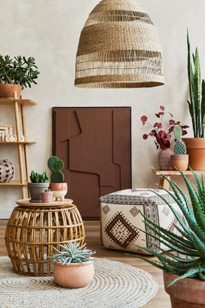 Stylish composition of cozy living room interior with structure painting, lot of plants, wooden cubes and boho accessories. Beige wall, carpet on the floor. Plants love concept. Template.の写真素材